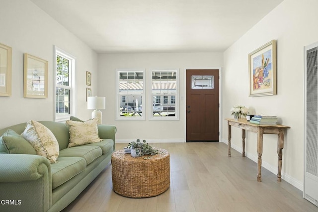 living area with baseboards and light wood finished floors