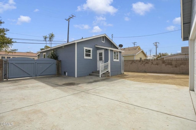 back of house with a patio area, fence, entry steps, and a gate