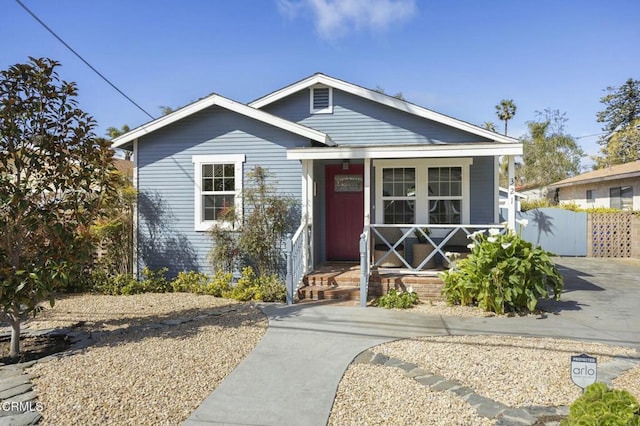 bungalow-style home featuring a porch and fence