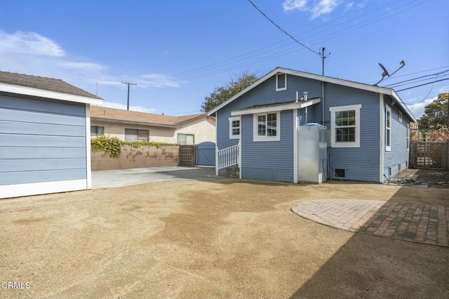 rear view of house with a patio area, a gate, and fence