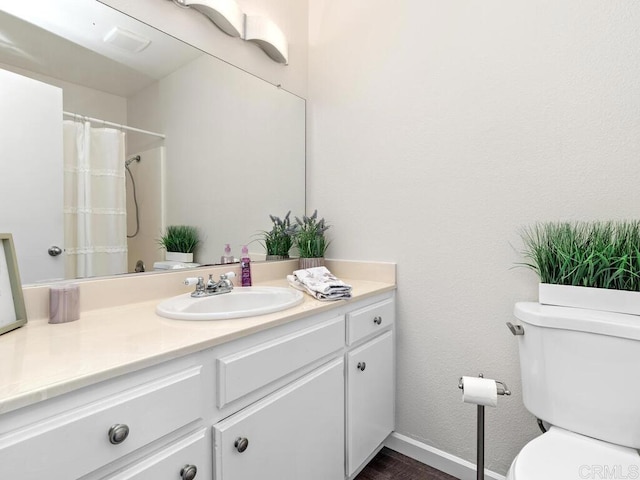 full bath featuring curtained shower, baseboards, vanity, and toilet