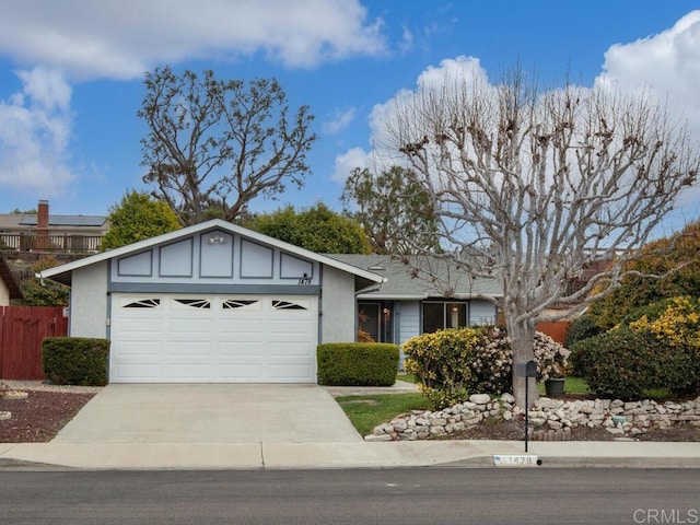 ranch-style home featuring stucco siding, driveway, an attached garage, and fence