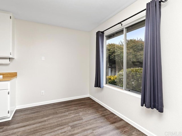 unfurnished room featuring baseboards and wood finished floors