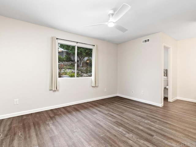 empty room featuring a ceiling fan, visible vents, baseboards, and wood finished floors