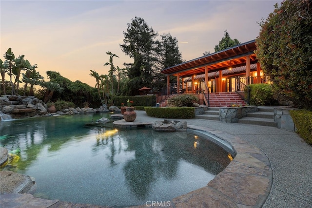 pool at dusk featuring stairs