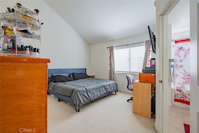 bedroom with tile patterned flooring, vaulted ceiling, and carpet flooring