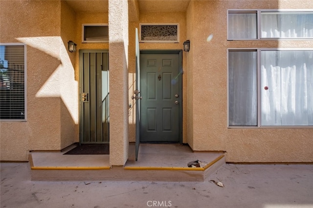 view of exterior entry with stucco siding