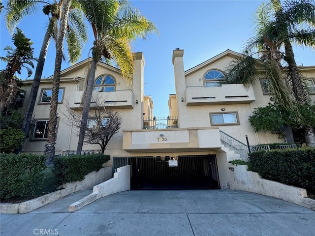 view of property with a garage and concrete driveway