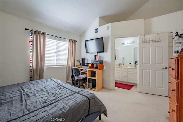 bedroom featuring ensuite bath, lofted ceiling, and carpet flooring