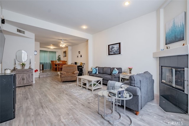 living area with visible vents, recessed lighting, a fireplace, and light wood-type flooring