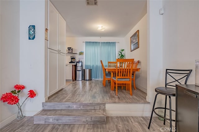 dining space featuring visible vents, baseboards, and wood finished floors