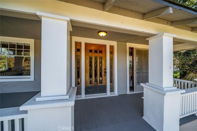 view of exterior entry featuring covered porch