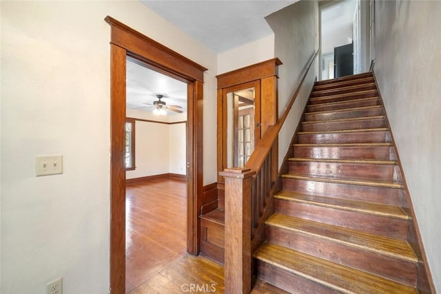 stairs featuring wood finished floors and baseboards