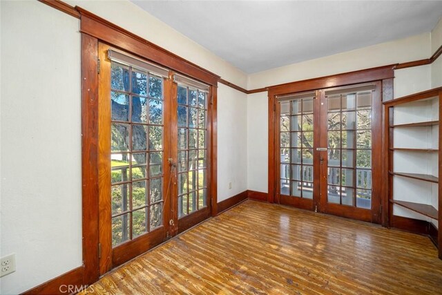 entryway with french doors, baseboards, and wood finished floors