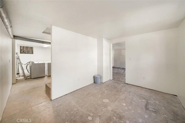 spare room with washer and dryer and unfinished concrete flooring