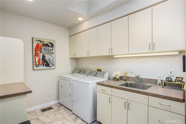 laundry area with a sink, visible vents, baseboards, washer and dryer, and cabinet space