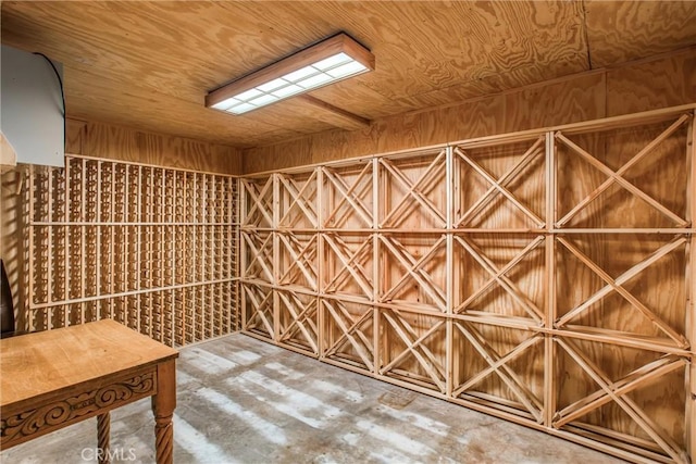 wine room with concrete flooring and wooden walls