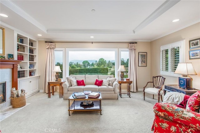 living room with ornamental molding, a tray ceiling, carpet, and a high end fireplace