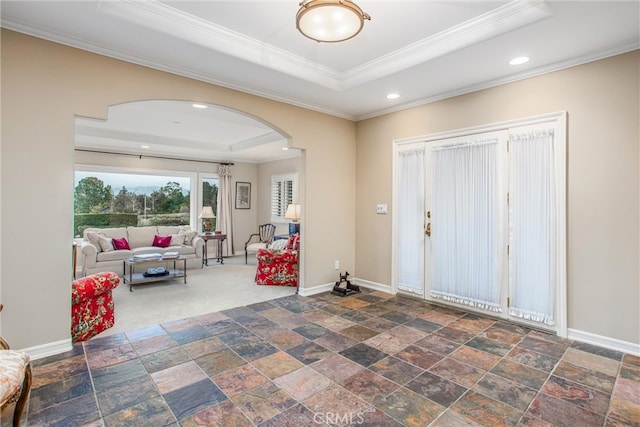 entryway with baseboards, arched walkways, a raised ceiling, crown molding, and recessed lighting