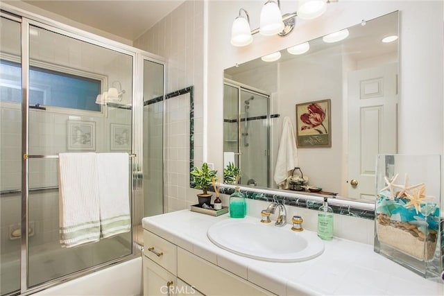 bathroom featuring bath / shower combo with glass door and vanity