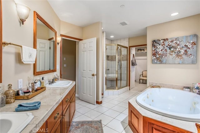 bathroom featuring double vanity, a stall shower, a sink, tile patterned flooring, and a jetted tub