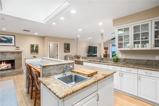 kitchen featuring open floor plan, a sink, and a center island with sink