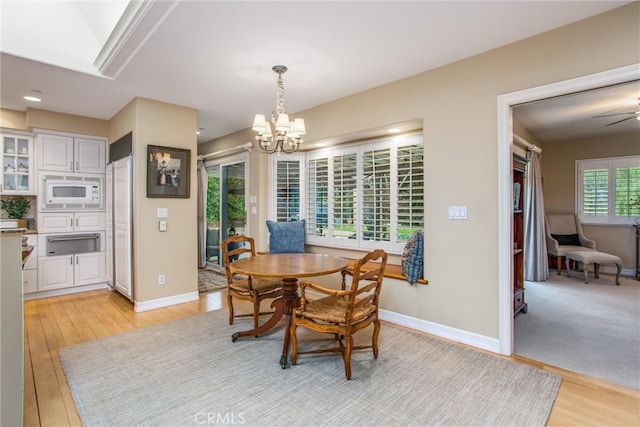 dining room with a chandelier, light wood-type flooring, baseboards, and recessed lighting