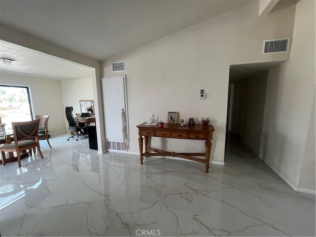 interior space featuring marble finish floor, visible vents, and vaulted ceiling