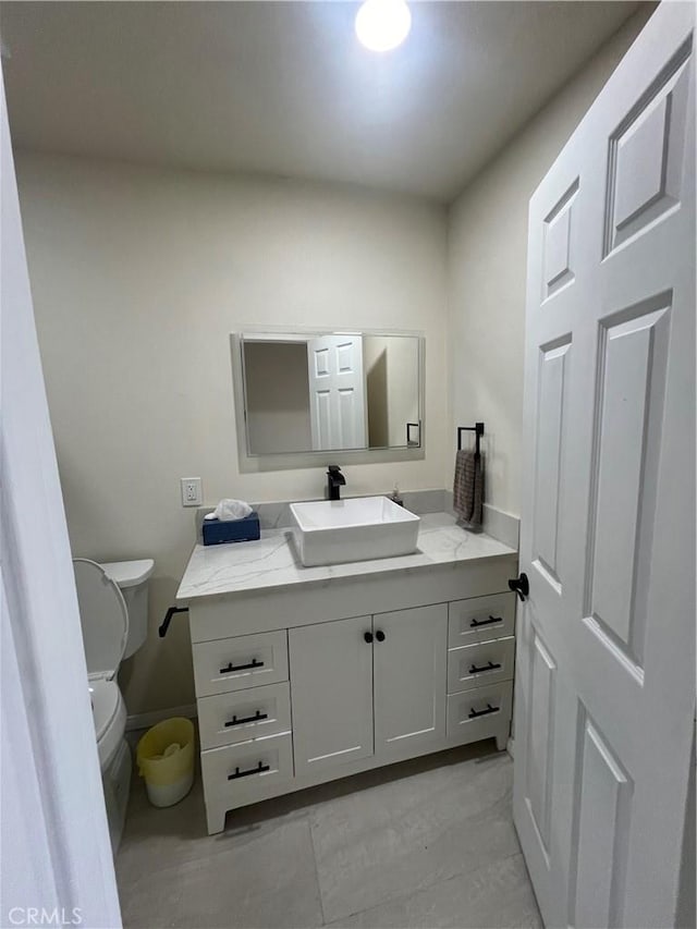 half bathroom with vanity and toilet