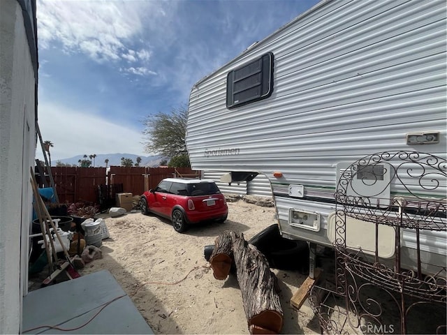 view of home's exterior featuring fence and a mountain view