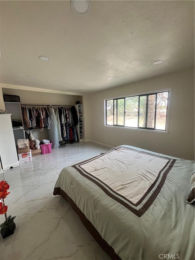 bedroom with a textured ceiling and marble finish floor