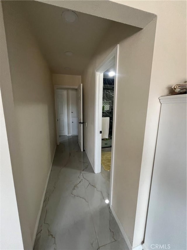 corridor with marble finish floor and baseboards