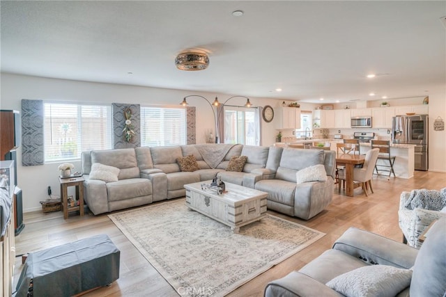 living area with light wood-style floors, recessed lighting, and baseboards