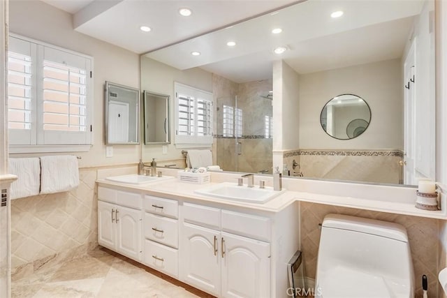 full bath featuring double vanity, a stall shower, a sink, and tile walls