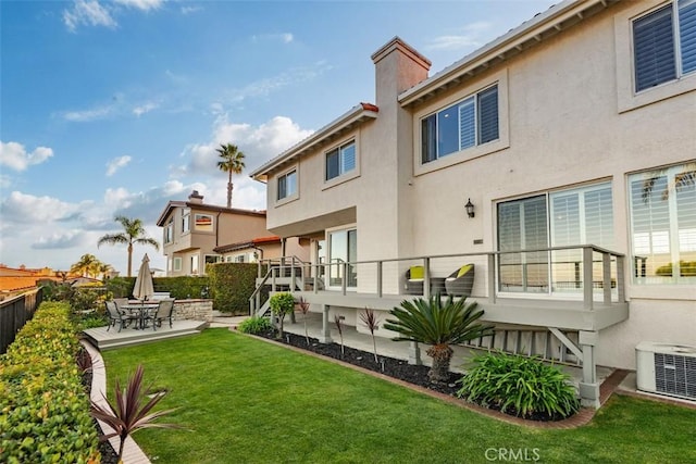 rear view of property featuring a lawn, a patio, fence, cooling unit, and stucco siding