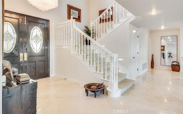 foyer entrance featuring baseboards, ornamental molding, and stairway