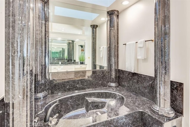 bathroom featuring ornate columns and vanity