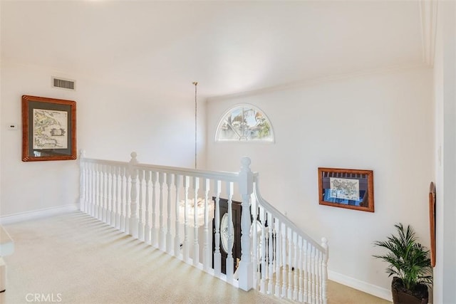 hall featuring an upstairs landing, carpet, visible vents, and baseboards