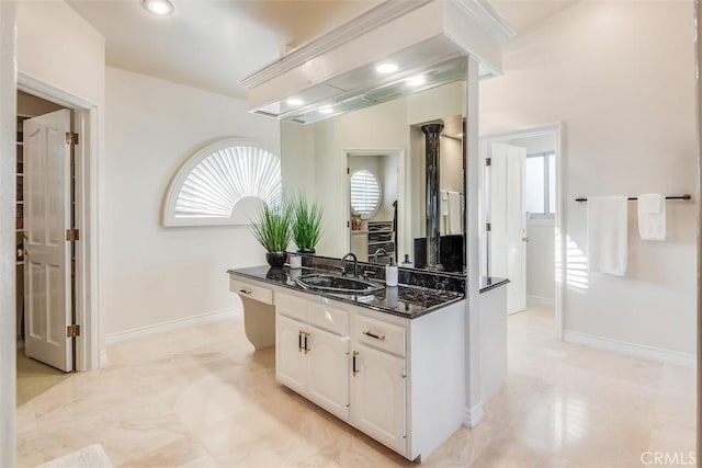 bathroom with a healthy amount of sunlight, baseboards, and vanity