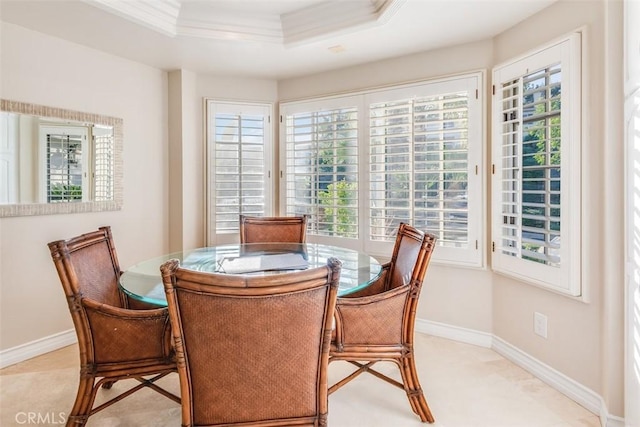 dining space featuring baseboards, a tray ceiling, and crown molding