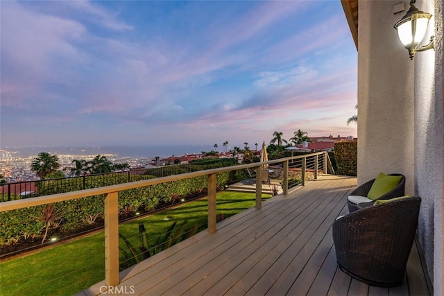 deck at dusk with fence and a lawn