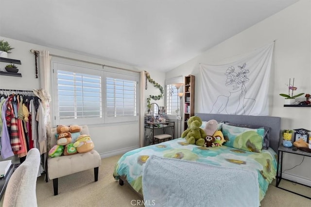 bedroom with vaulted ceiling, carpet flooring, and baseboards