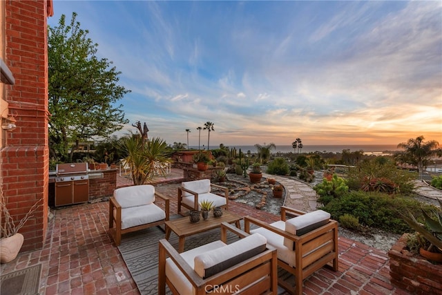 view of patio / terrace featuring an outdoor living space, a grill, and exterior kitchen