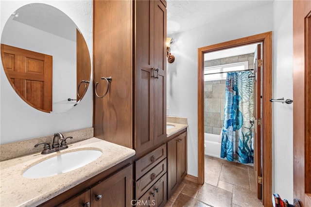 bathroom featuring vanity, stone tile floors, and shower / tub combo with curtain