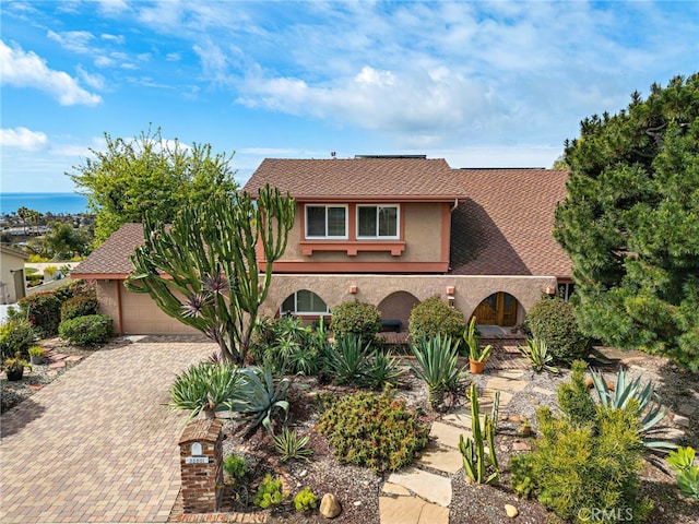 view of front of property with stucco siding, decorative driveway, and a garage