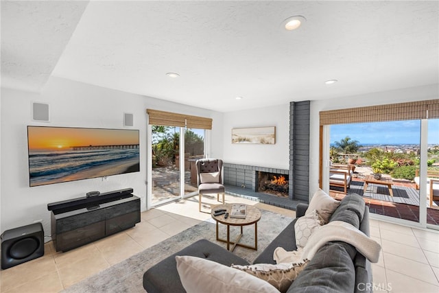 living area with tile patterned floors, recessed lighting, a fireplace, and a textured ceiling