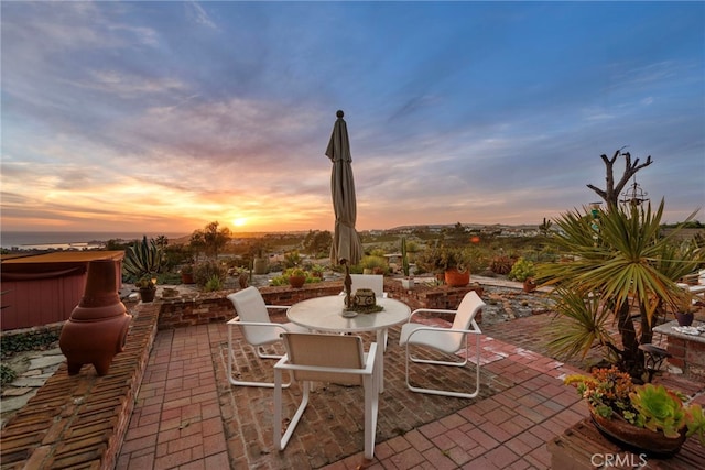 view of patio with outdoor dining area and a hot tub