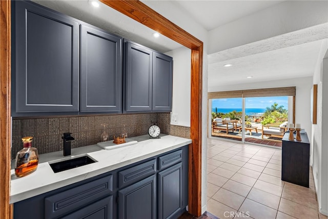 kitchen featuring light tile patterned flooring, recessed lighting, tasteful backsplash, and a sink