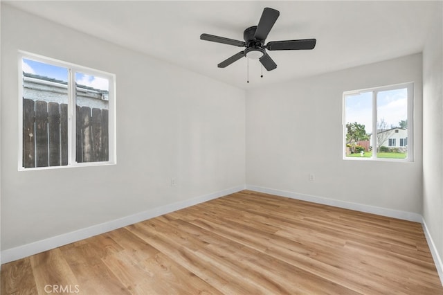 unfurnished room featuring baseboards, a ceiling fan, and light wood-style floors