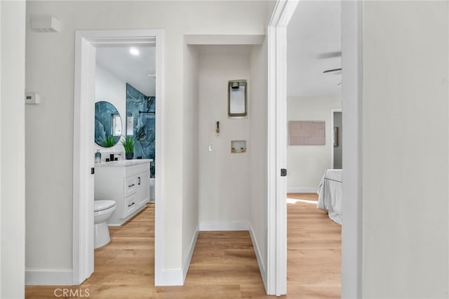 hall featuring light wood-style floors and baseboards